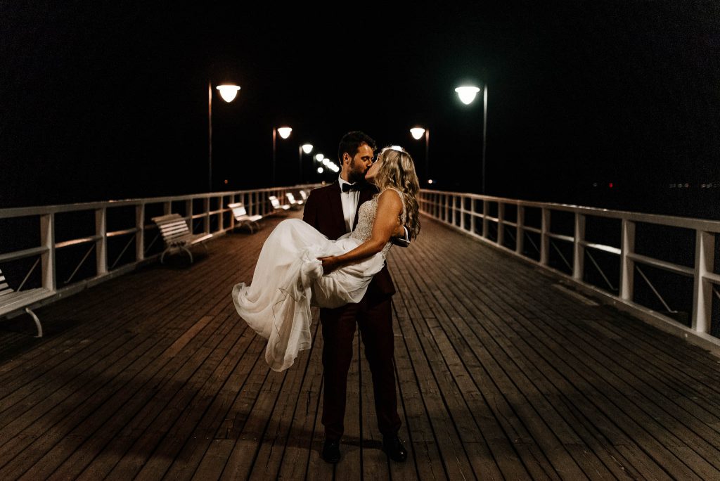 Fotograf ślubny z parą młodą na molo w mieście Gdynia