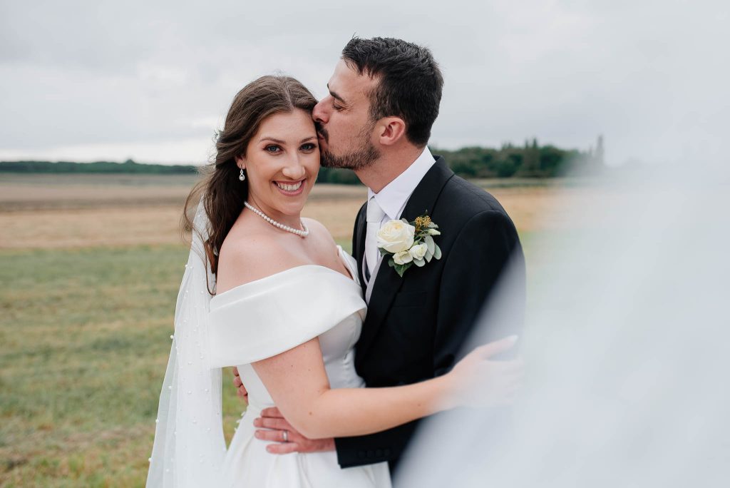 Pocałunek pary po wymianie obrączek podczas symbolicznego momentu ślubnego we dwoje